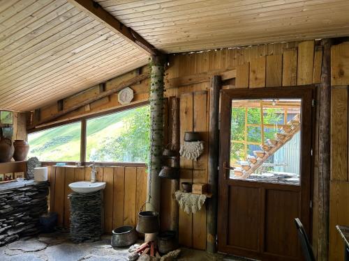 eine Holzhütte mit einem Waschbecken und einem Fenster in der Unterkunft Shio's Stonehouse in Tusheti in Tusheti