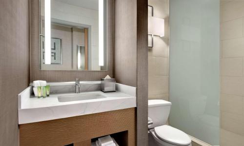 a bathroom with a sink and a toilet and a mirror at Enticing Stay at Strat Casino STRIP Las Vegas in Las Vegas