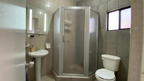 a bathroom with a shower and a toilet and a sink at Condominiums Boutique Madera 3 in Ciudad Juárez