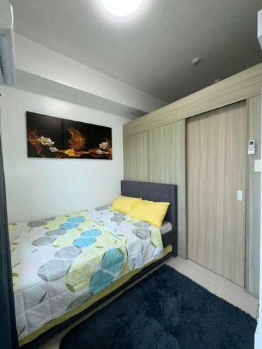 a bedroom with a bed and a painting on the wall at Night Blink Staycation and Rentals in Manila