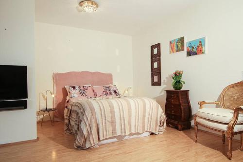 1 dormitorio con 1 cama, 1 silla y TV en ☆Luxuriöses Apartment☆ Central MUC Enjoy & relax en Múnich