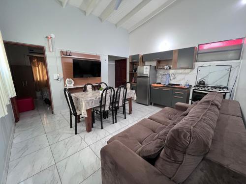sala de estar con sofá, mesa y cocina en Sirius Apart en Puerto Iguazú