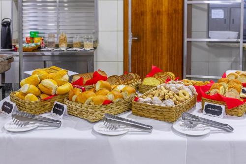 uma mesa com várias cestas de frutas sobre ela em Hotel Caminho do Rosário em Aparecida
