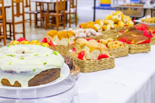 uma mesa coberta com um bolo e cestas de frutas em Hotel Caminho do Rosário em Aparecida