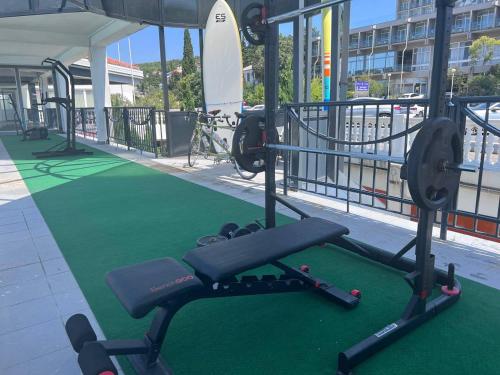 a gym with a bench and a green treadmill at Hotel Millenium deluxe in Selce