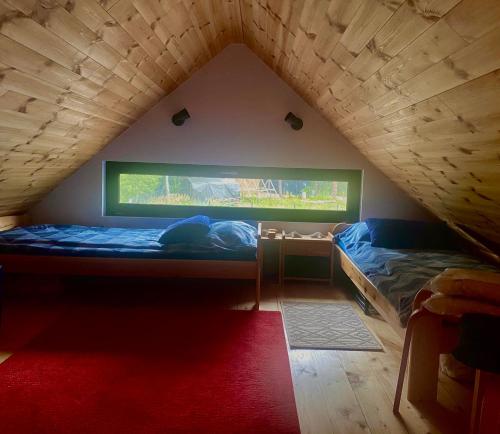 Pokój z łóżkiem i oknem na poddaszu w obiekcie Domek ,, Daglezja ” w Dziwnowie