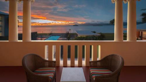 two chairs on a balcony with a view of the ocean at Grand Pacific Hotel in Suva