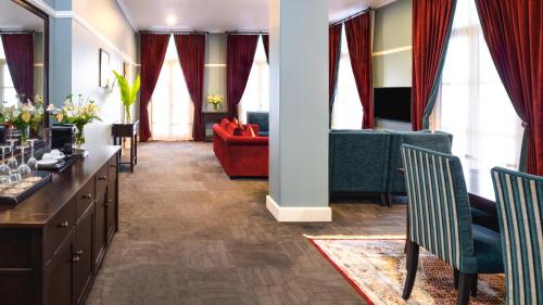 a living room with a couch and a table and chairs at Grand Pacific Hotel in Suva