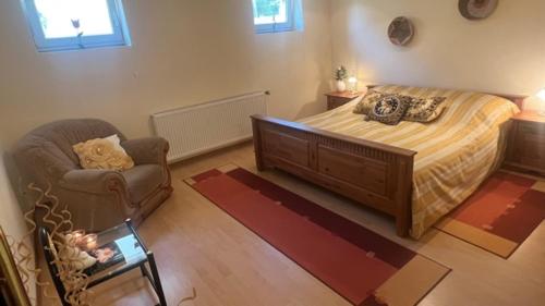a bedroom with a bed and a chair and a couch at Ferienwohnung-Schluecke in Bad Frankenhausen