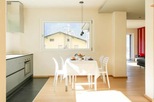 a kitchen and dining room with a white table and chairs at Style apartments VdA in Senin