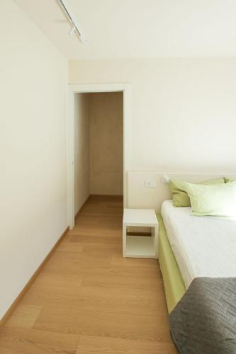 a white bedroom with a bed and a table at Style apartments VdA in Senin
