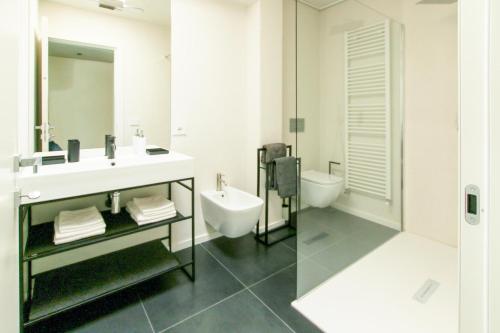 uma casa de banho branca com um lavatório e um WC em Style apartments VdA em Senin