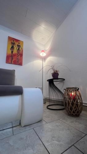 a living room with a white couch and a table at Ferienwohnung-Schluecke in Bad Frankenhausen