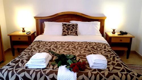 a bedroom with a bed with towels and flowers on it at Palazzo Zimatore Residenza D'Epoca in Pizzo