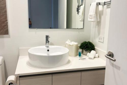 a white bathroom with a sink and a mirror at Studio in Hallandale 2B/1B amazing views in Hallandale Beach