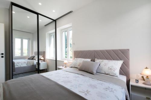 a bedroom with a large bed and two windows at Lalù in Split