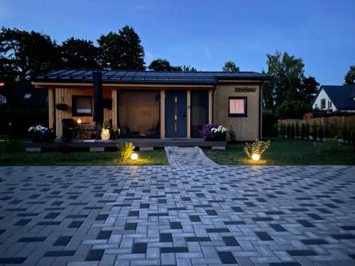 a tiny house with a patio and lights at Jūras dzintars in Ainaži