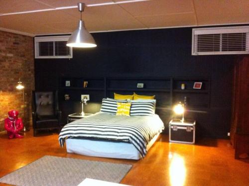 ein Schlafzimmer mit einem großen Bett mit gelben und weißen Kissen in der Unterkunft The Coachhouse in Goulburn