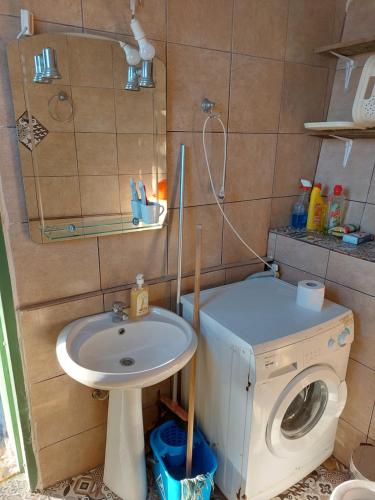 ein Badezimmer mit einem Waschbecken und einer Waschmaschine in der Unterkunft Paradise lost in Kalamata