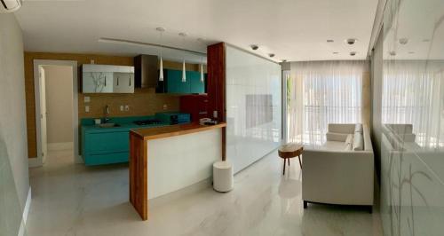 uma cozinha com armários azuis, uma mesa e um sofá em Ipanema Wave Apart Hotel de Luxo Y11-005 no Rio de Janeiro