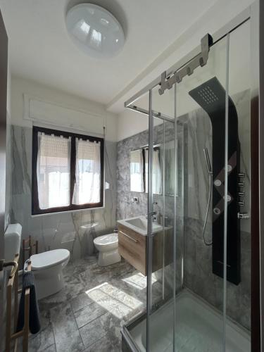 La salle de bains est pourvue d'une douche, de toilettes et d'un lavabo. dans l'établissement Bed and Breakfast Onde Beach, à Su Forti