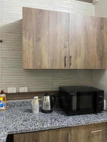 a kitchen with a black microwave and a counter top at Modern Apartment 3 room in Sheikh Zayed N5 الشيخ زايد in 6th Of October