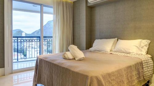 um quarto com uma cama e uma janela grande em Ipanema Wave Apart Hotel de Luxo Y11-005 no Rio de Janeiro