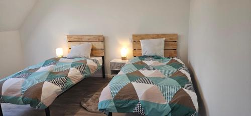 deux lits côte à côte dans une pièce dans l'établissement Sur la route des plages, à Saint-Philibert