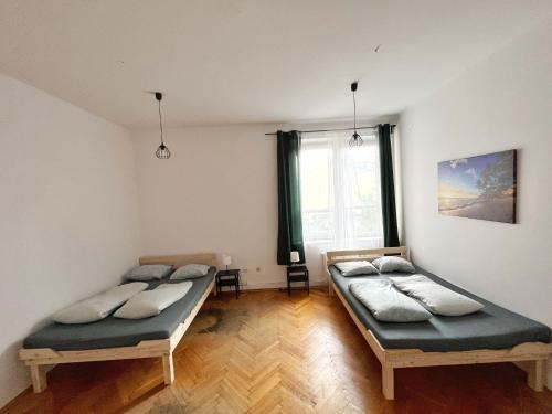 two twin beds in a room with a window at Nice View Rooms In Old Town in Krakow