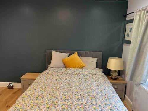 a bedroom with a bed with a blue wall at En-suite Double Room - Private Entrance & Free Parking in West Drayton