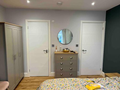 a bedroom with a bed and a mirror and a dresser at En-suite Double Room - Private Entrance & Free Parking in West Drayton
