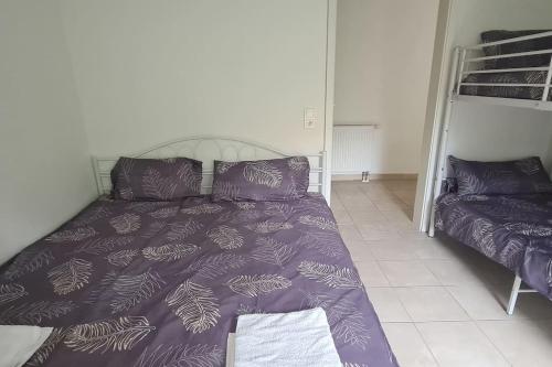 ein Schlafzimmer mit einem Bett mit einer lila Bettdecke in der Unterkunft Beauty Apartment near Messe City and Airport with Garden in Köln