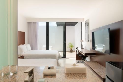 a hotel room with a bed and a television at Fiesta Inn Playa del Carmen in Playa del Carmen