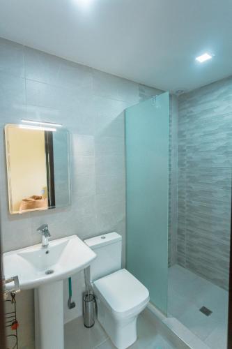 a bathroom with a toilet and a sink and a shower at Khata's cozy place in Bakuriani