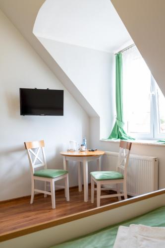 a room with a table and two chairs and a tv at Hotel Rozmaryn i Lawenda in Minikowo