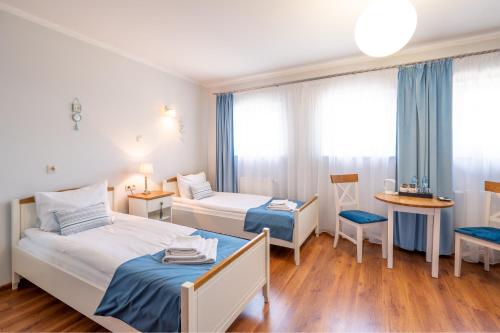 ein Hotelzimmer mit 2 Betten und einem Tisch in der Unterkunft Hotel Rozmaryn i Lawenda in Minikowo