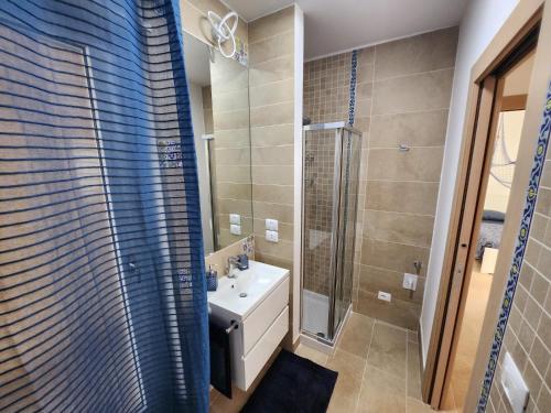 La salle de bains est pourvue d'un lavabo et d'une douche. dans l'établissement Rifugio di Mare - Appartamento Vasto Marina, à Vasto