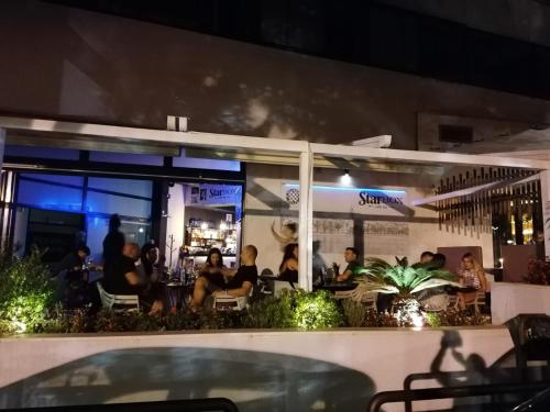 Split Ruža Apartment في سبليت: مجموعة من الناس يجلسون في مطعم في الليل