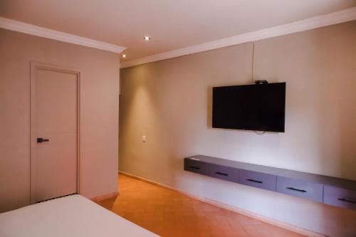 a bedroom with a tv on the wall and a bed at Mikaella Hotel in San Miguel de Allende