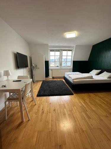 a bedroom with a bed and a desk and a table at Linz -central condo in Linz