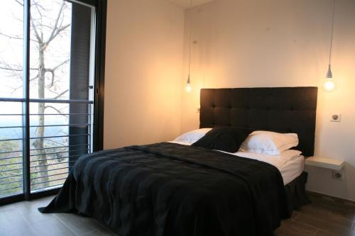 Valle-di-CampoloroにあるVilla Petreraのベッドルーム(大型ベッド1台、大きな窓付)