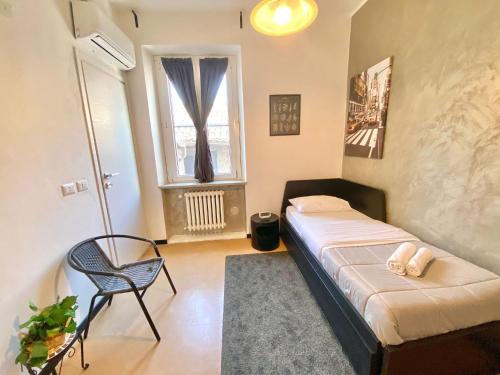 a bedroom with a bed and a chair and a window at Maison Sarraj Affittacamere in Parma