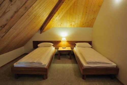 a room with two beds and a table with a lamp at Vasaknų dvaras in Žabičiūnai