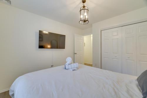 a bedroom with a white bed with a tv on the wall at 7 Mi to Camelback Mtn Chic Penn Estates Home in East Stroudsburg
