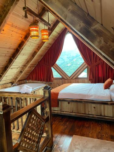 Un dormitorio con una cama y una ventana grande en Asmoca Bungalov, en Rize
