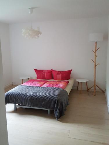 a bedroom with a bed with red pillows and a table at Waldhaus in Neu Drefahl