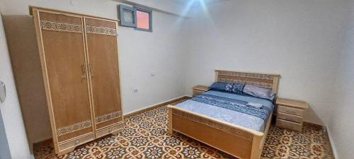 a bedroom with a bed and a large cabinet at Breeze apart - 2 facade & WiFi in Al Hoceïma