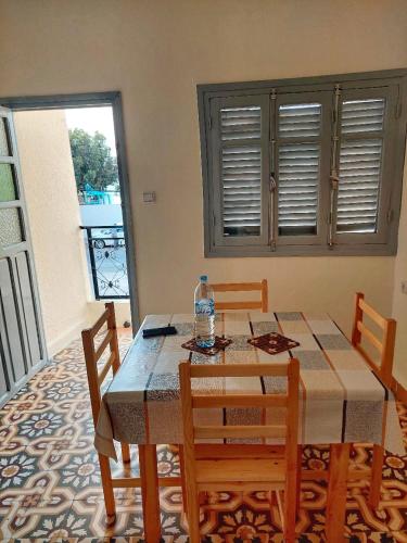 comedor con mesa, sillas y ventana en Breeze apart - 2 facade & WiFi, en Alhucemas