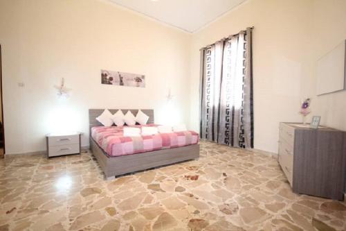 ein Schlafzimmer mit einem Bett und einem großen Fenster in der Unterkunft Le Tre Rose Di Mary in Avola