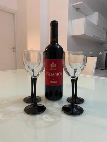 eine Flasche Wein und zwei Weingläser auf dem Tisch in der Unterkunft Nunzia’s house! in Castel Volturno